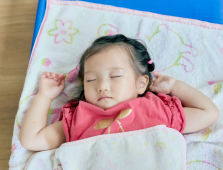 タオルケットをかけて眠る子ども
