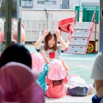 園庭で先生と遊ぶ子どもたち
