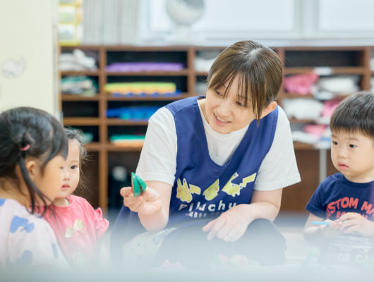 先生と一緒に遊ぶ子どもたち