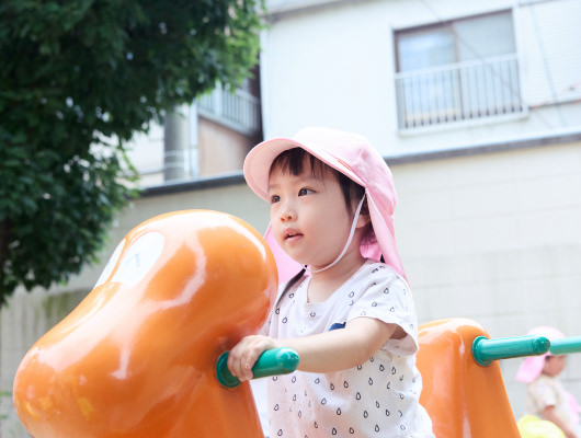 園庭の遊具で遊ぶ子ども