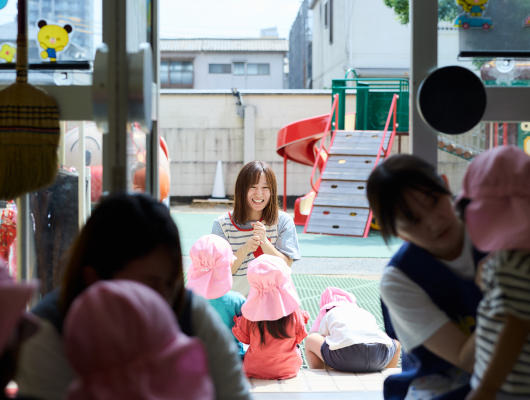 園庭で子どもたちと過ごす先生